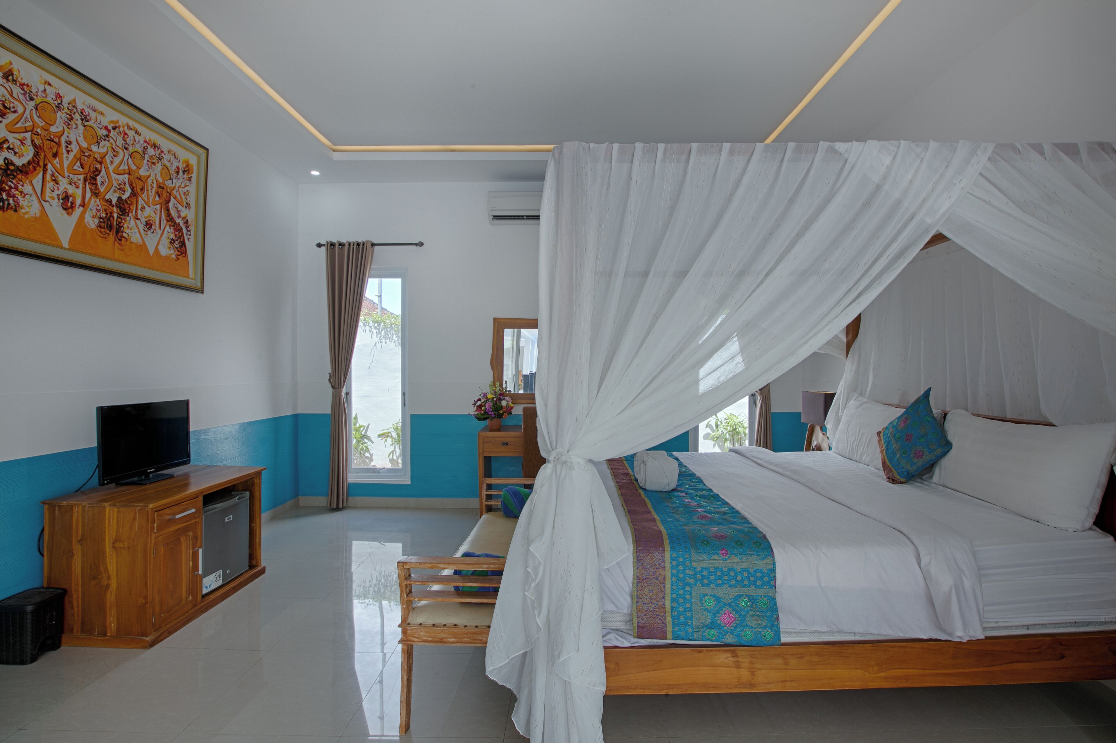 A bedroom with a canopy bed, a television on a wooden cabinet, and a painting on the wall.