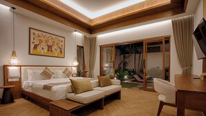 A modern bedroom with a bed, sofa, desk, and large windows.