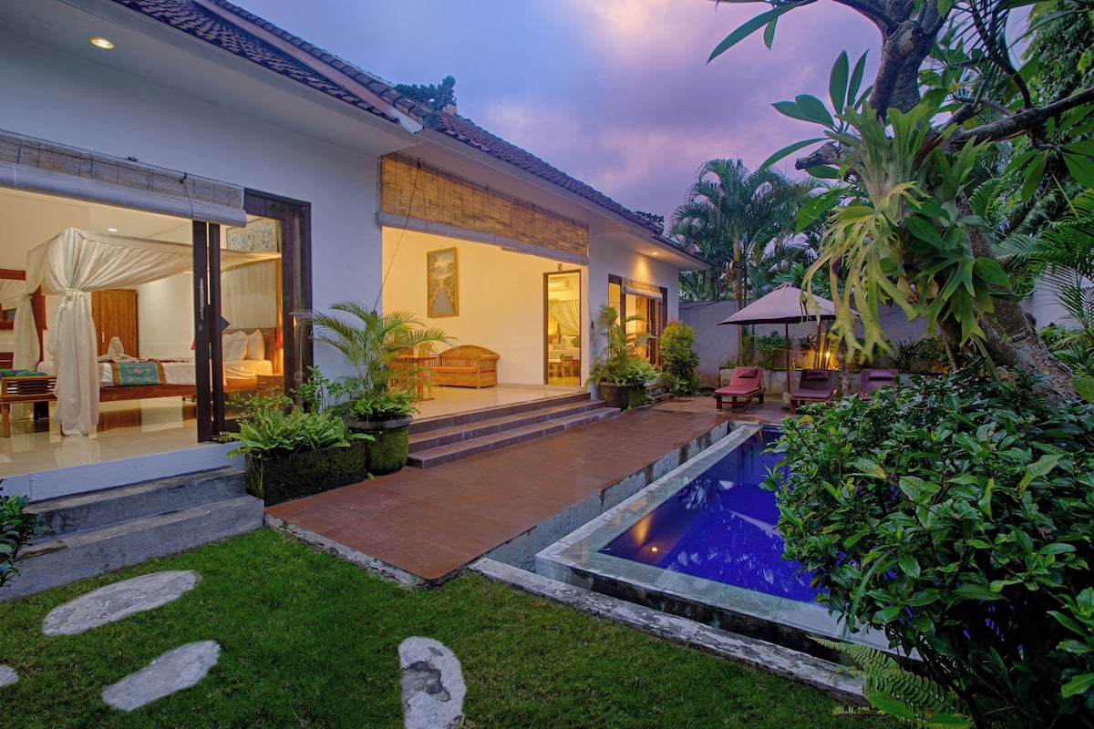 Une villa moderne dotée d’une piscine, d’un espace salon extérieur abrité et d’une végétation luxuriante.