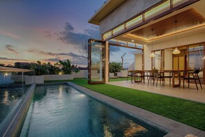A modern house with a swimming pool, glass doors, and a dining area. - My Villa and Resort Canggu (Canggu)