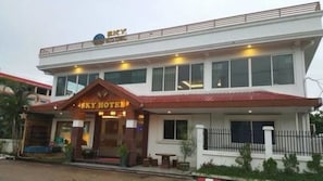 Un hotel de dos pisos con un llamativo letrero que dice 'SKY HOTEL' en la planta baja.