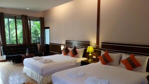A hotel room with two beds, a sofa, a TV, and a window with curtains. - Banana Place Resort (Chumphon)
