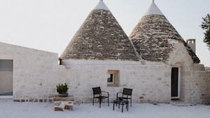 A rustic building with two conical roofs, a small window, and two chairs in front. - Villa Torre Bianca by Emily Hotels (Polignano a Mare)