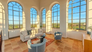 A spacious living room with a large window, a sofa, a coffee table, and a chair. - Villa Torre Bianca by Emily Hotels (Polignano a Mare)
