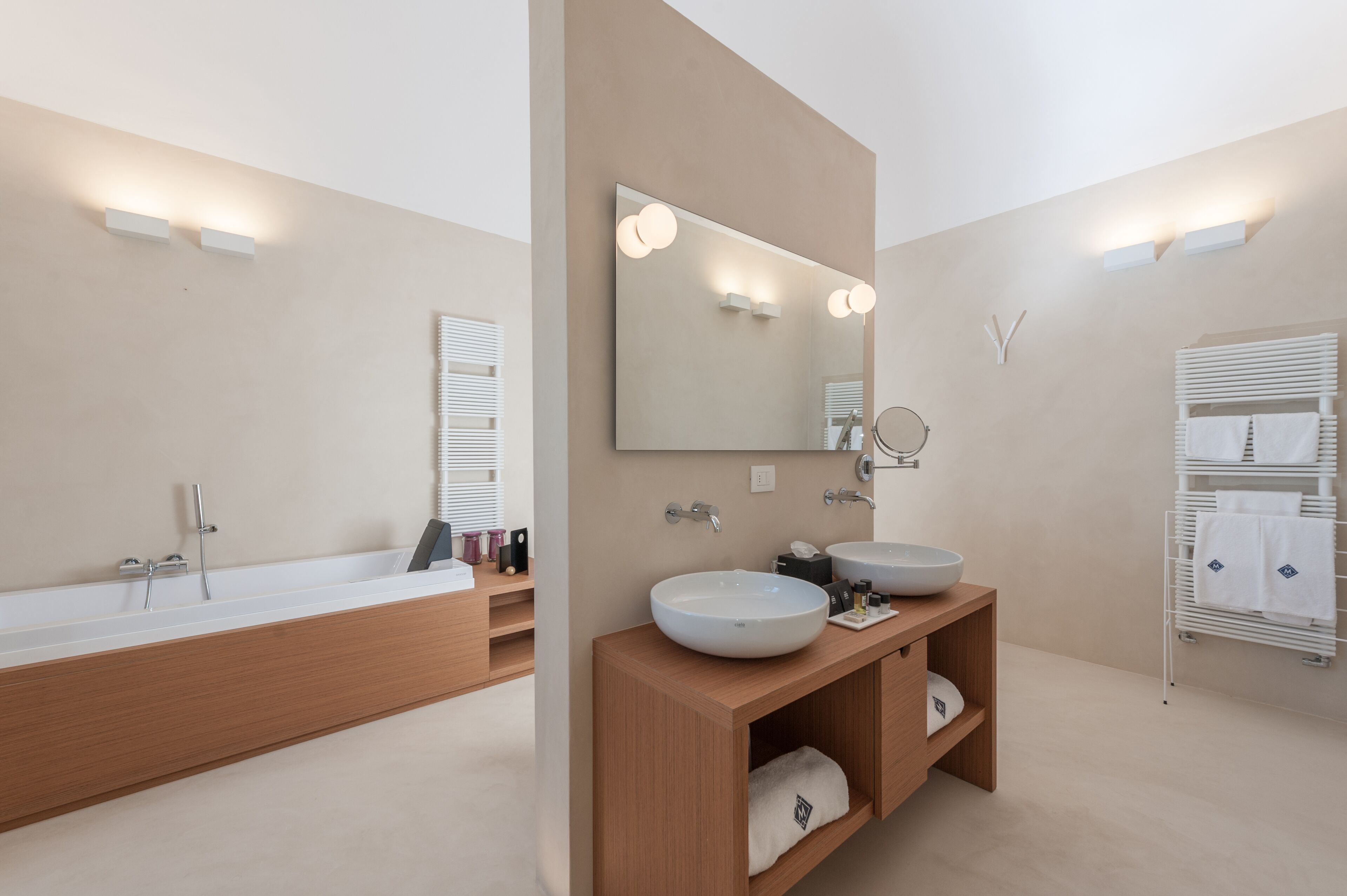 Ein modernes Badezimmer mit einer großen Badewanne, zwei Waschbecken und einem Waschtisch mit Ablageflächen.