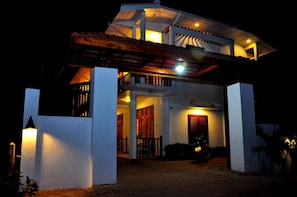 A two-story house with a covered porch and a staircase leading to the upper floor. - London Palace (Anuradhapura)