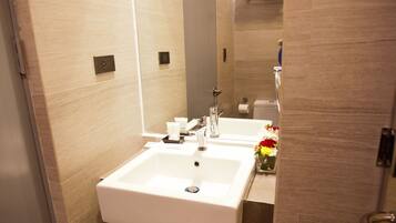 Un baño moderno con dos lavamanos, un espejo y una ducha.