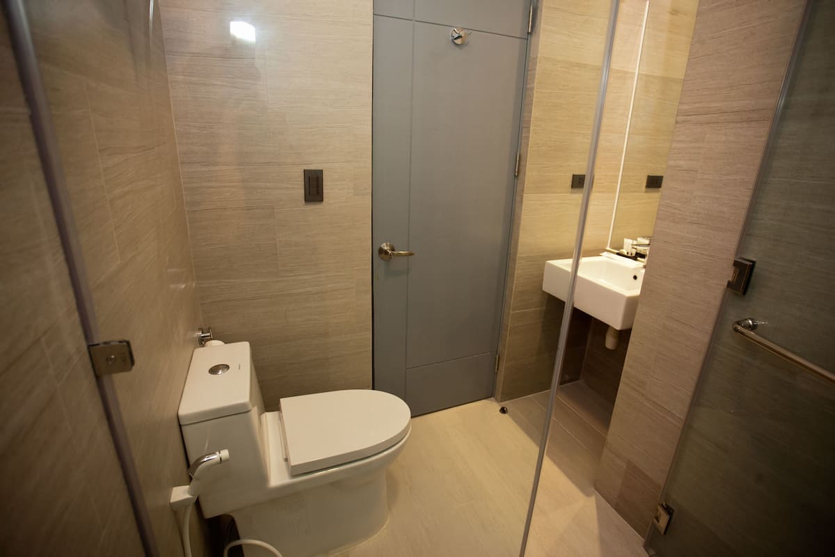 Un baño moderno con inodoro, lavabo y cabina de ducha.