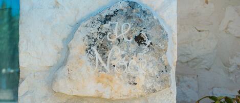 A stone with the inscription "Le Noce" on a building wall.