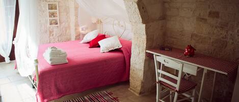 A bedroom with a bed, a desk, and a chair.