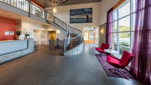 A spacious lobby with a staircase, a reception desk, and seating area. - Dolmsundet Hotell Hitra (Hitra)
