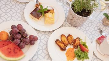 Una mesa dispuesta con platos de comida, incluyendo uvas, sandía y una taza de café.