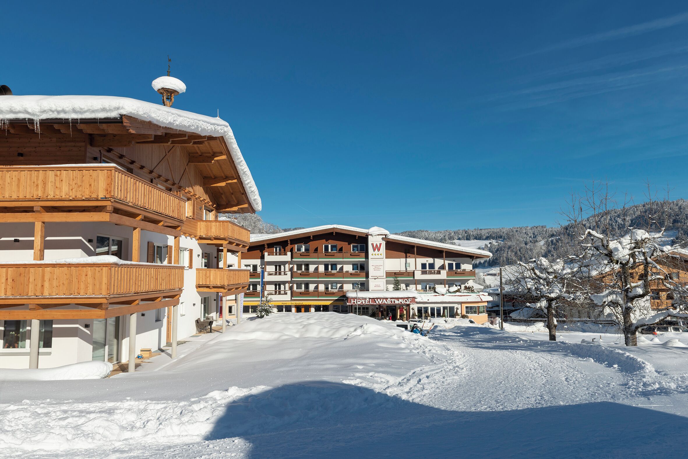 Un hotel con varios balcones, un telesilla y un paisaje nevado.