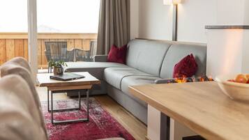 Una sala de estar moderna con un sofá gris, una mesa de centro de madera y una alfombra roja.