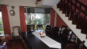 A dining area with a long table, chairs, and a staircase. - Hanthana Breeze Home Stay (Kandy)