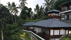 A traditional Japanese-style house with a tiled roof, surrounded by lush greenery and a small pond. - Suarapura Resort & Spa (Sebatu)