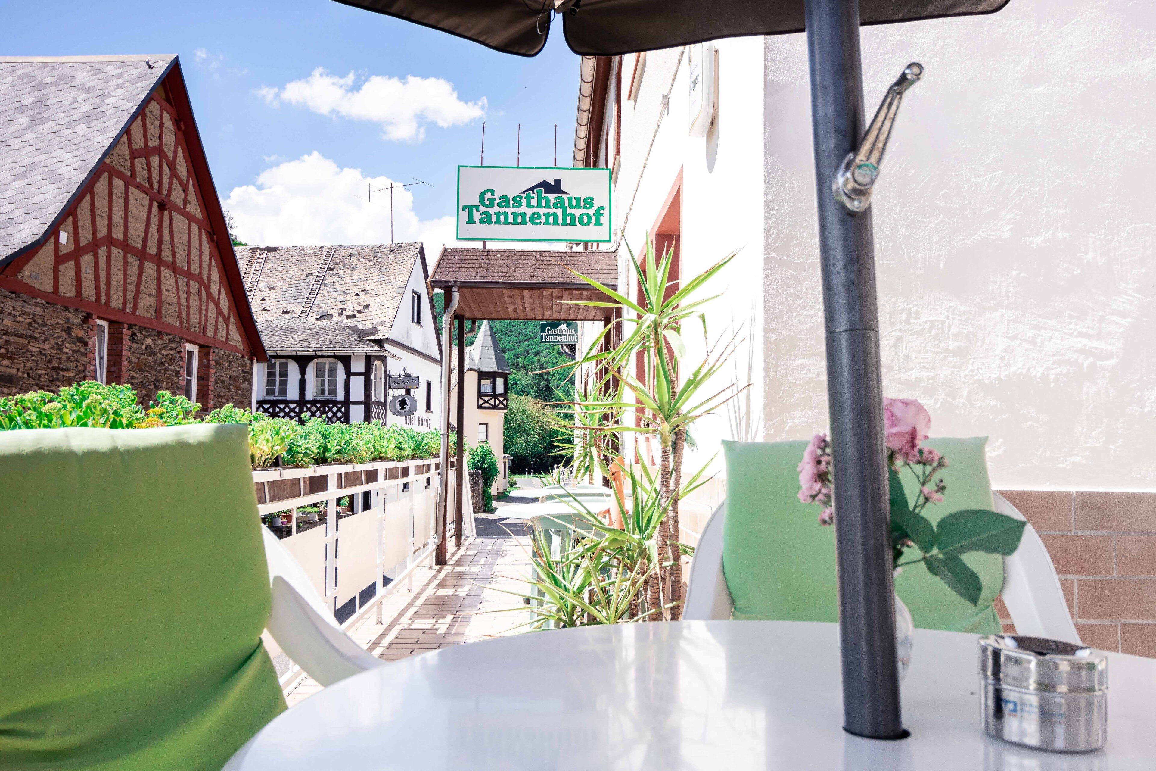 A restaurant named "Gasthaus Tannenhof" with a view of the street and traditional buildings.