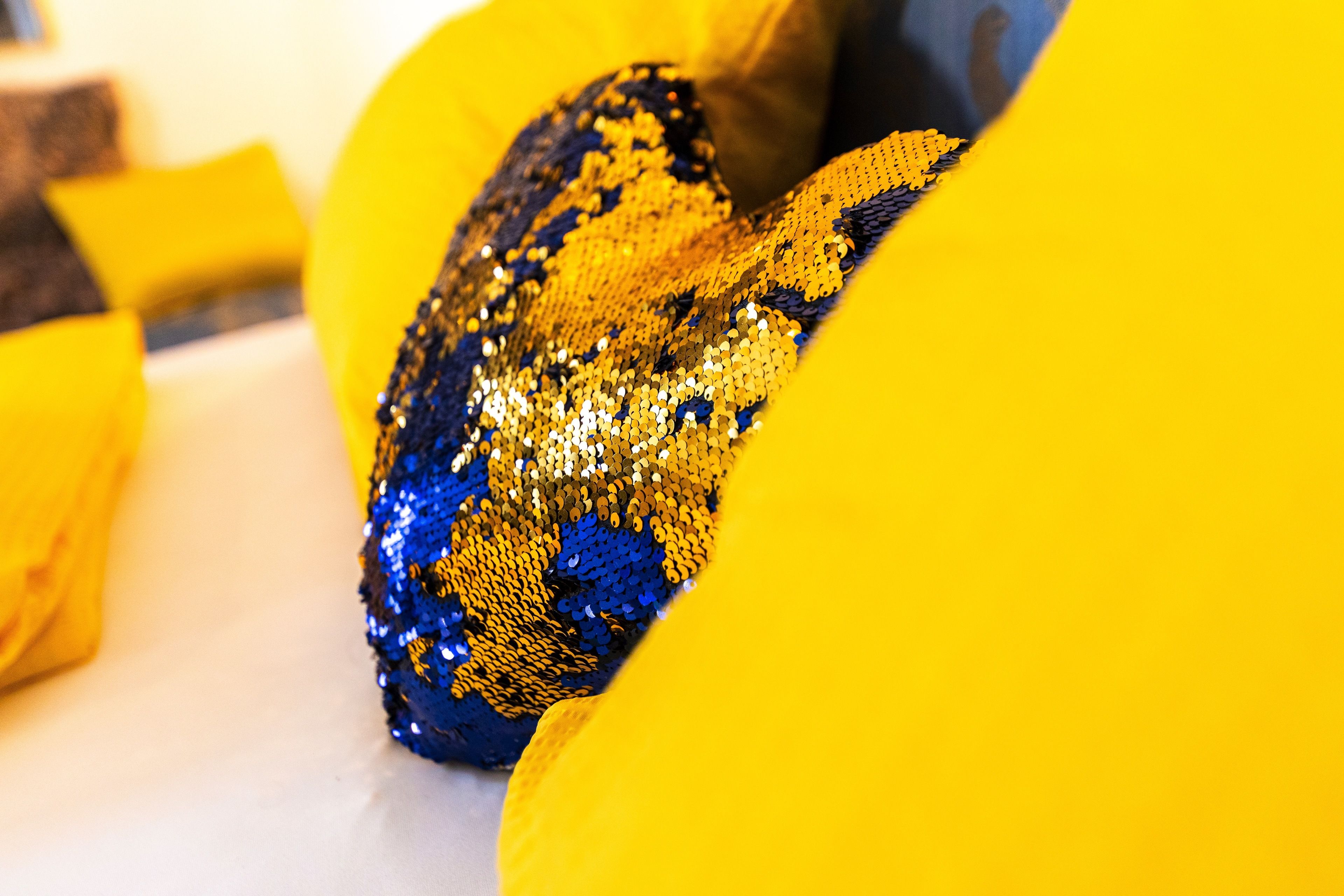 A close-up of a sequined fabric with a pattern of blue and gold.