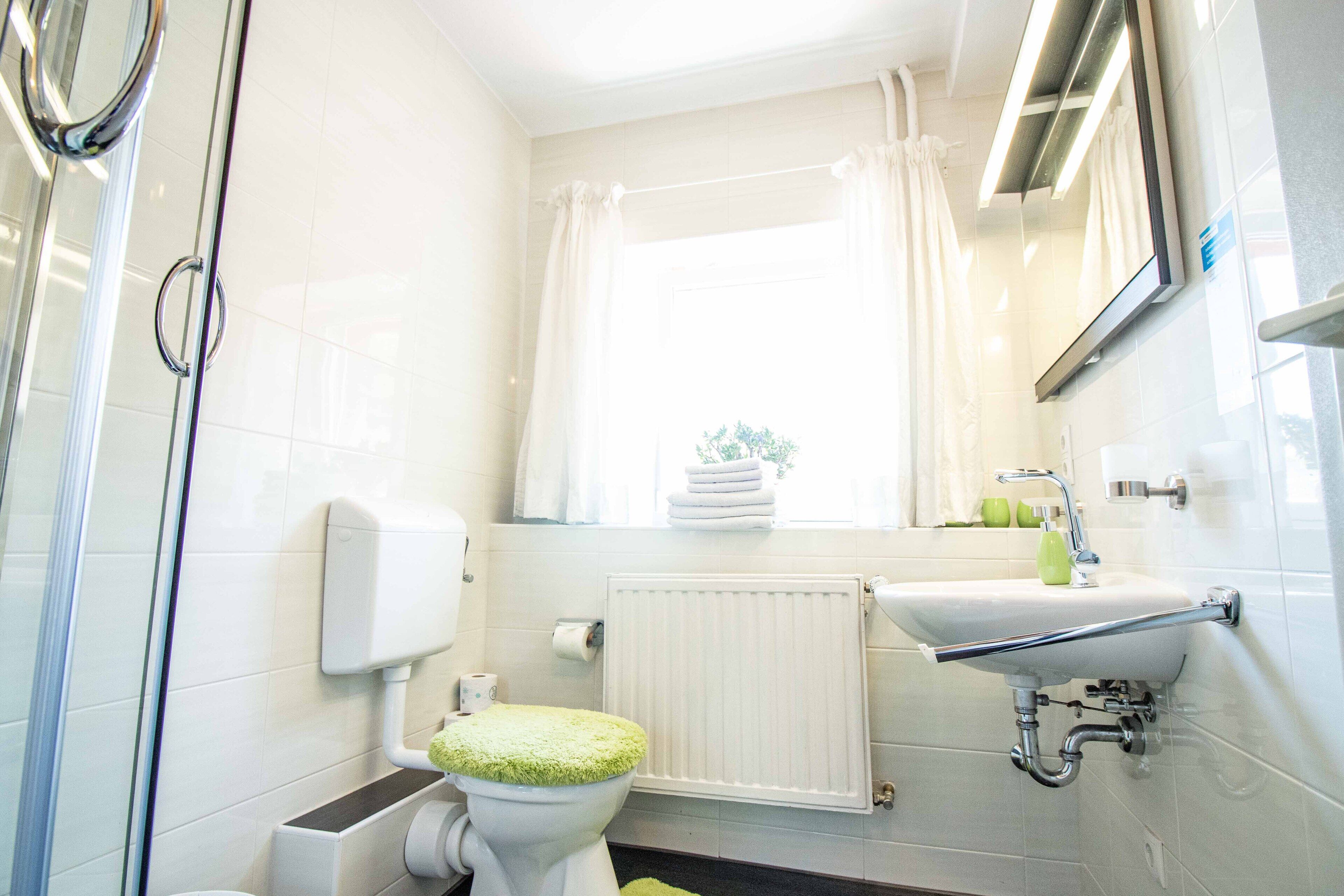 Une salle de bain avec des toilettes, un lavabo et une douche.