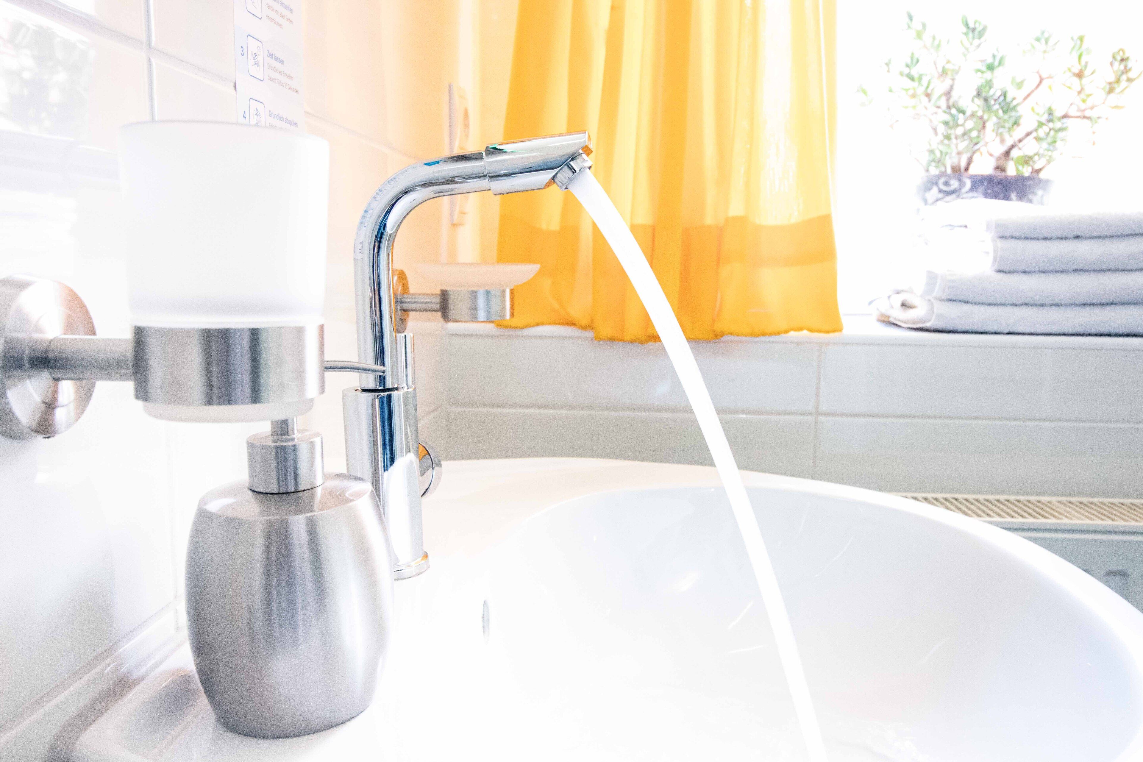 Ein Badezimmer mit einem modernen Waschbecken, einem Wasserhahn und einer Toilette.