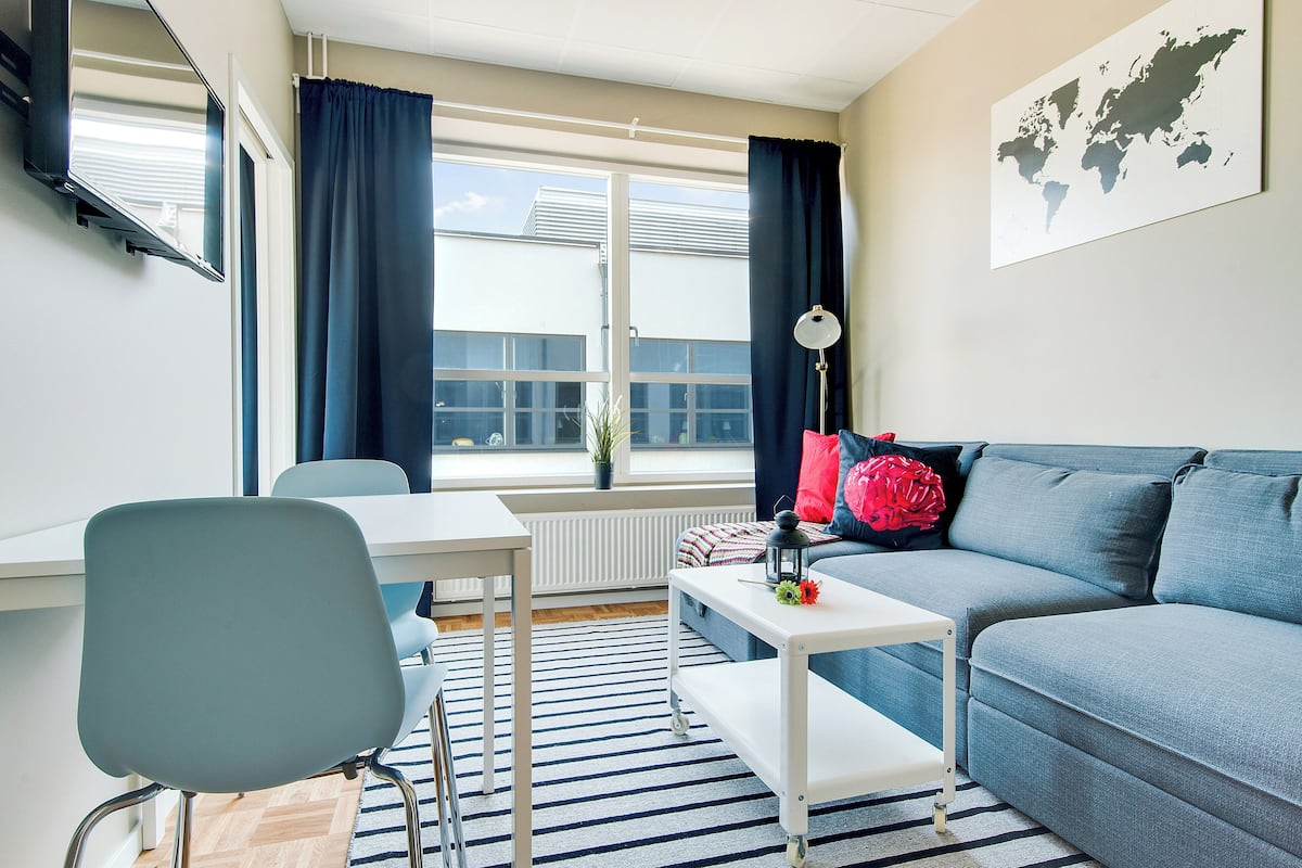 Ein modernes Wohnzimmer mit einer Couch, einem Esstisch und einem Sessel.