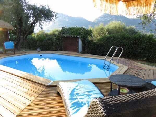 Una piscina al aire libre, sillones reclinables de piscina