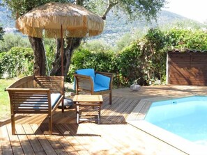 Una piscina al aire libre, sillones reclinables de piscina