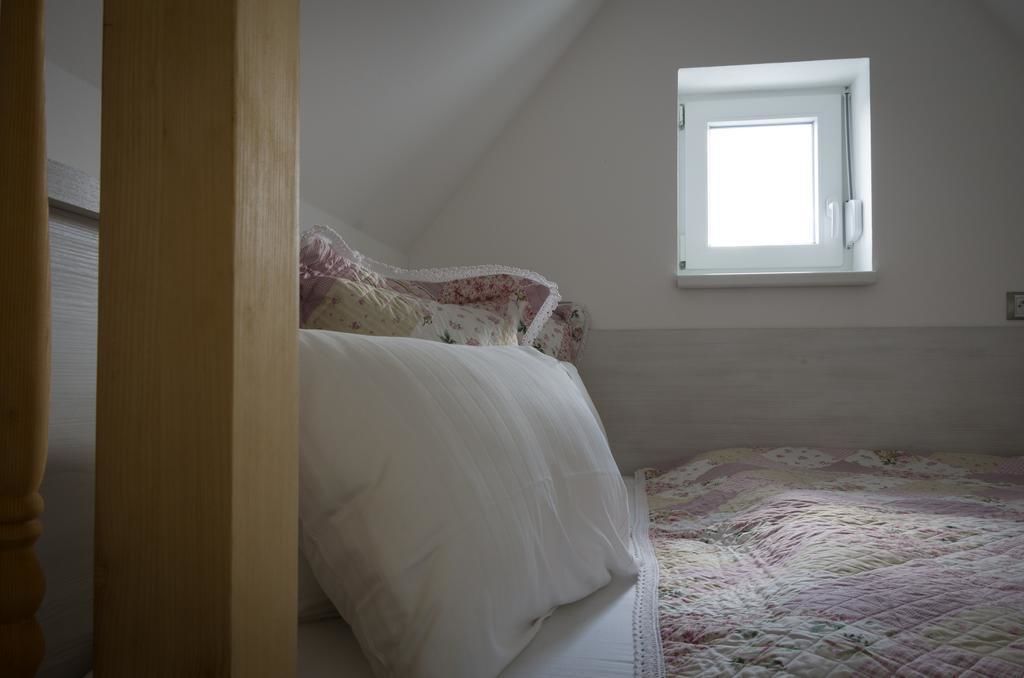 A bedroom with a bed, a window, and a door.