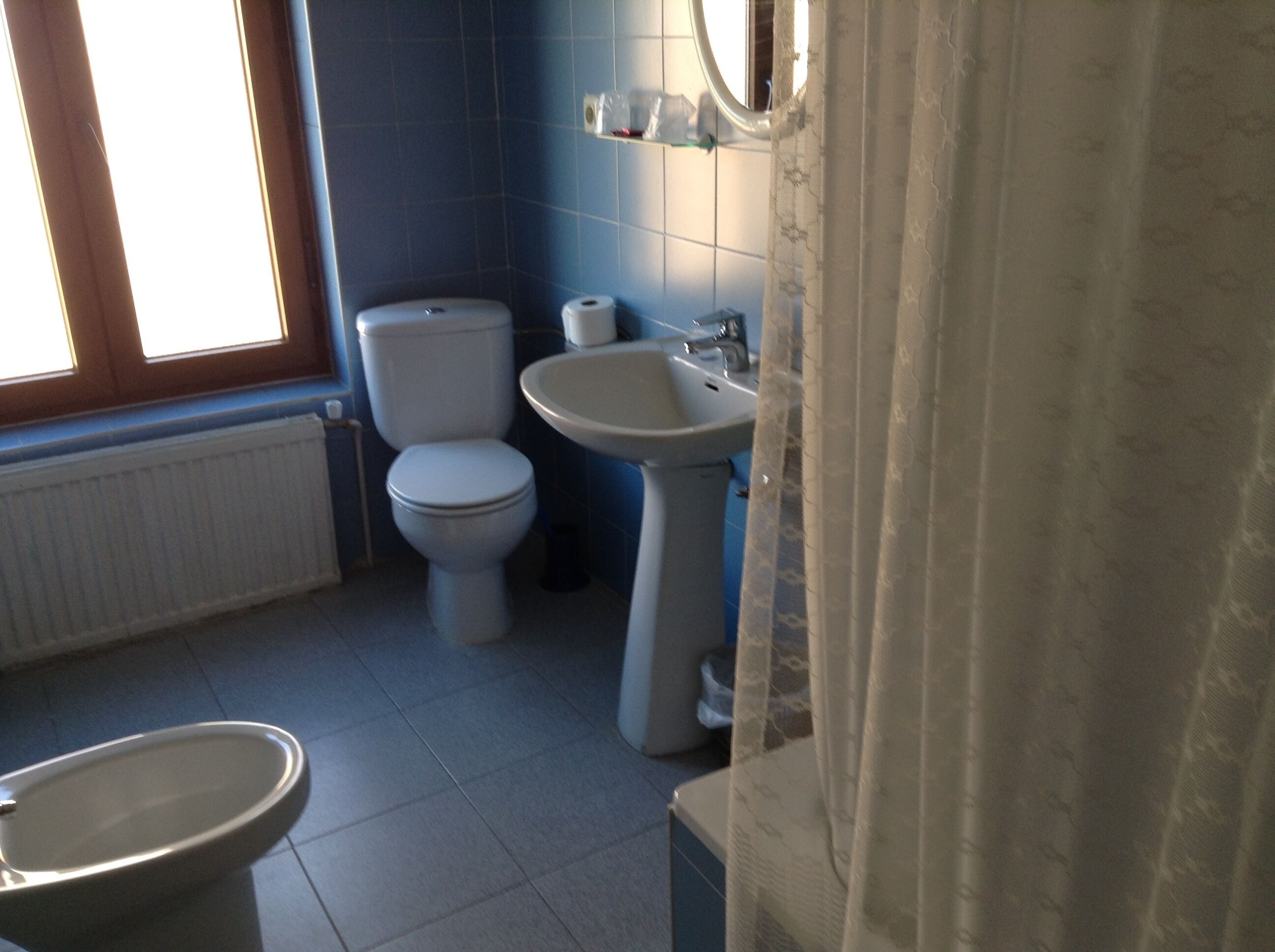 Un baño con inodoro, lavamanos y bidé.