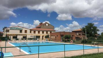 Una piscina al aire libre, sombrillas, tumbonas