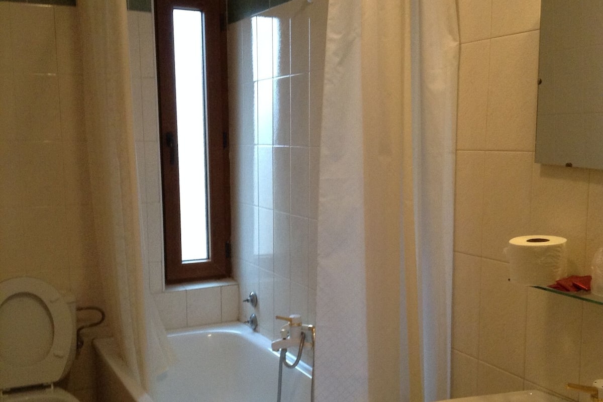 A bathroom with a bathtub, toilet, and sink.