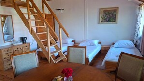 A wooden staircase leading to a loft bedroom with a bed and a desk area with a chair and a table. - Villa Zosieńka (Gdansk)