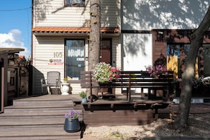 A wooden bench with potted plants, a chair, and a building with a sign 'SOLID SECURITY' and a mailbox. - Villa Zosieńka (Gdansk)