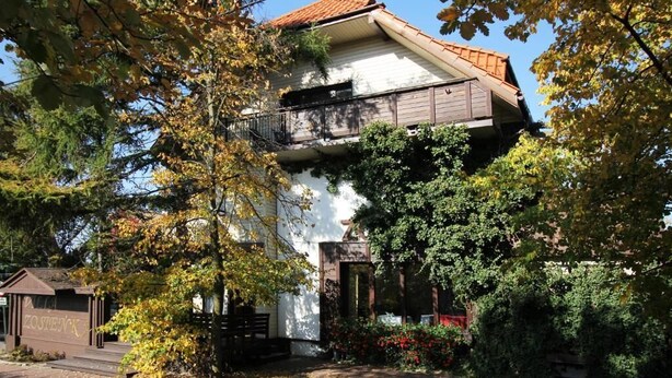 A two-story house with a balcony, surrounded by trees and a garden. - Villa Zosieńka (Gdansk)