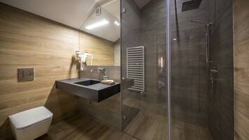 Un bagno moderno con doccia vetrata, lavabo integrato con specchio e WC.