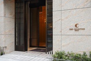 A modern hotel entrance with a marble facade and a glass door. - Hotel The Celestine Ginza (Tokyo)