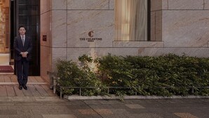 A man standing outside a building with a sign that reads "The Christine Cinema." - Hotel The Celestine Ginza (Tokyo)
