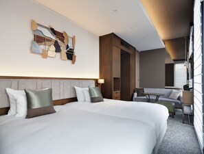 A hotel room with a large bed, a desk, a chair, and a view of the outside.