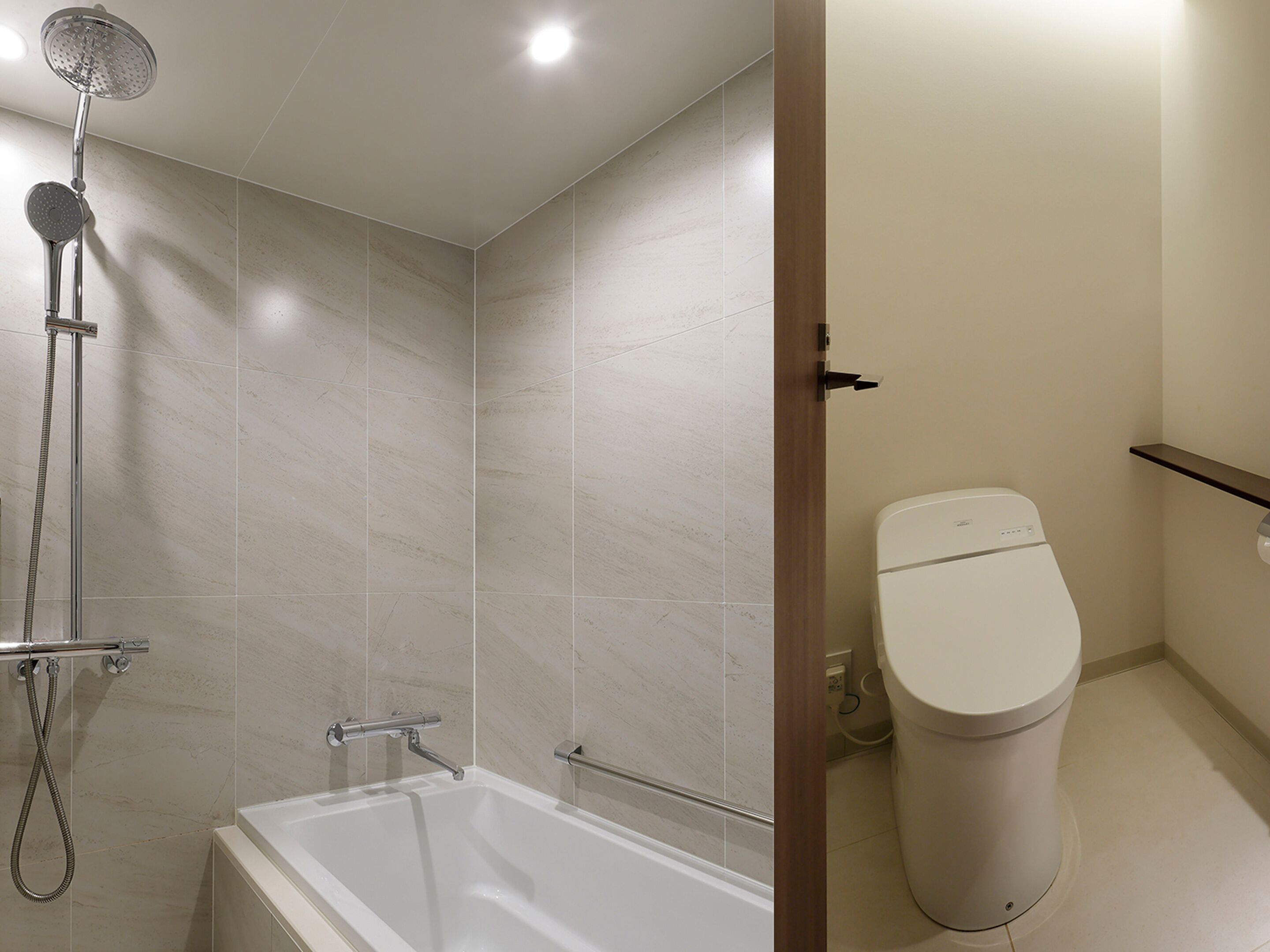 A bathroom with a bathtub, shower, and toilet.
