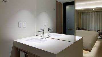 A modern bathroom with a large mirror, two sinks, and a wooden cabinet.