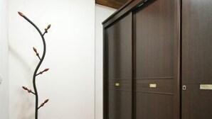 Una habitación con piso de madera, un armario de madera oscura y una escultura decorativa de una rama.