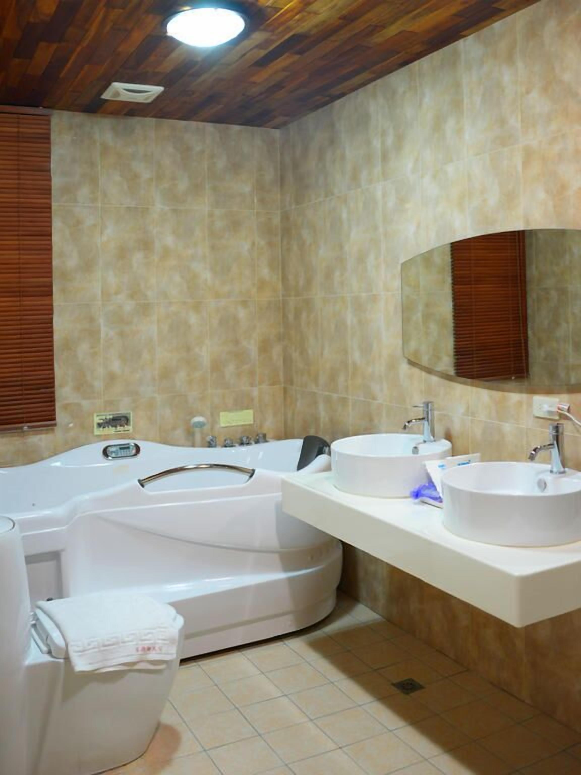 A bathroom with a freestanding bathtub, two sinks, and a large mirror.