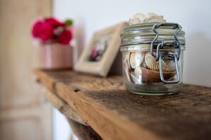 A glass jar with a metal clasp containing seashells, placed on a wooden surface. - Le Mazet de Tourrettes (Tourrettes-sur-Loup)