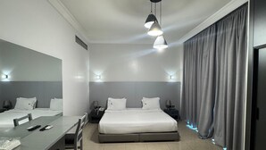 Una habitación de hotel moderna con cama, mesitas de noche, escritorio y armario.