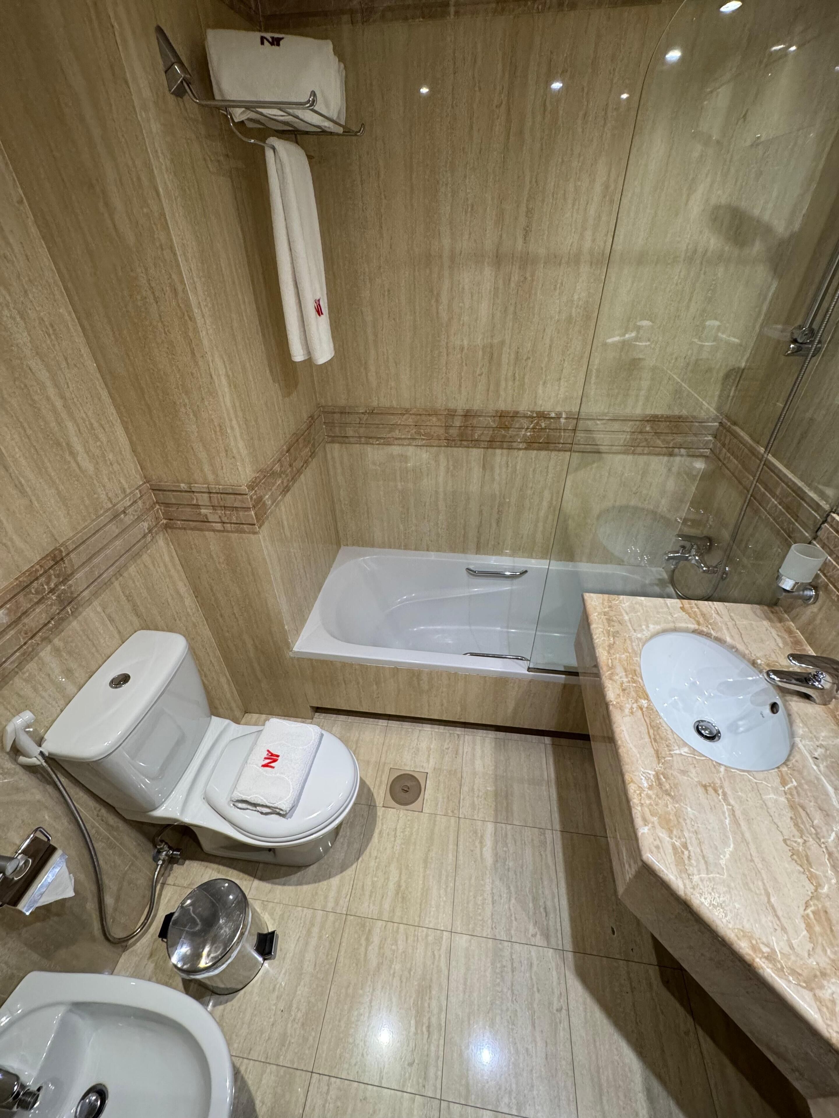Un baño moderno con inodoro, bidé, bañera y lavamanos.
