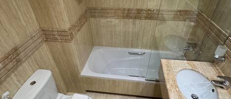 Un baño moderno con inodoro, bidé, bañera y lavamanos.