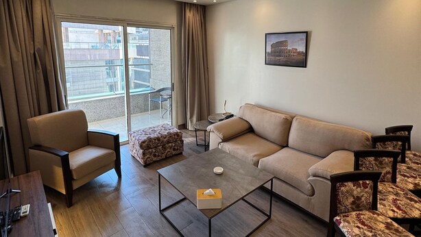 Una sala moderna con un sofá, sillones, una mesa de centro y una zona de comedor.