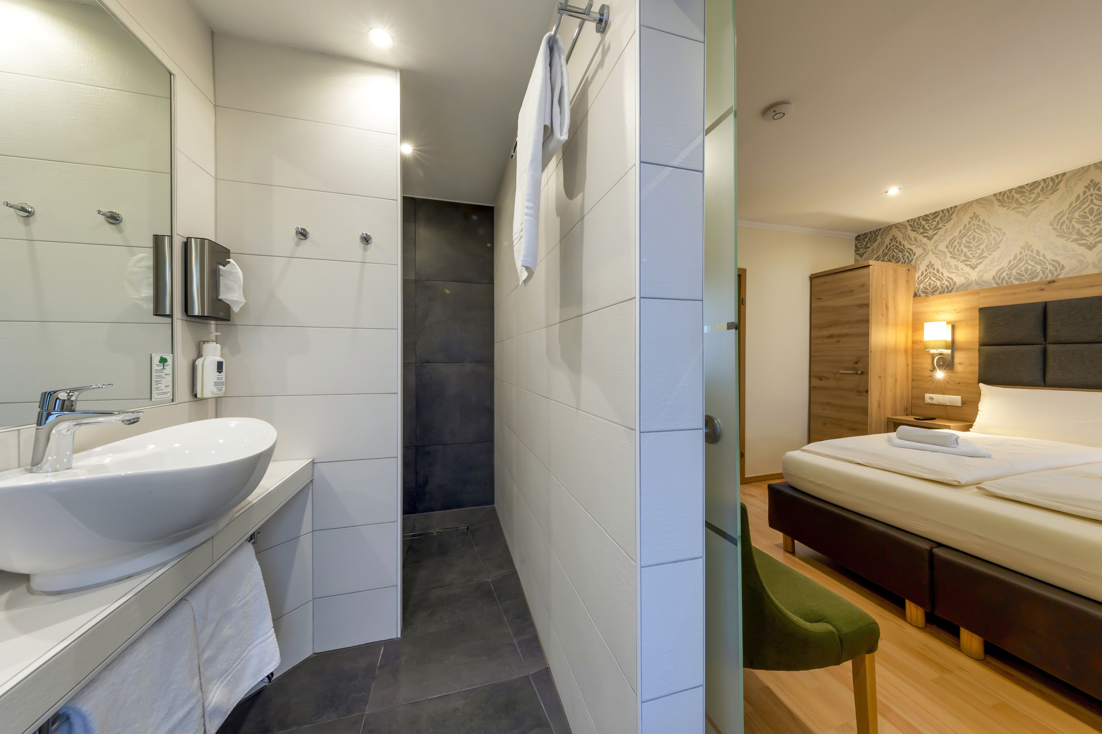 Une salle de bain moderne avec un grand lavabo, un miroir et une douche.