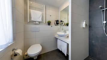 A modern bathroom with a toilet, sink, and shower.
