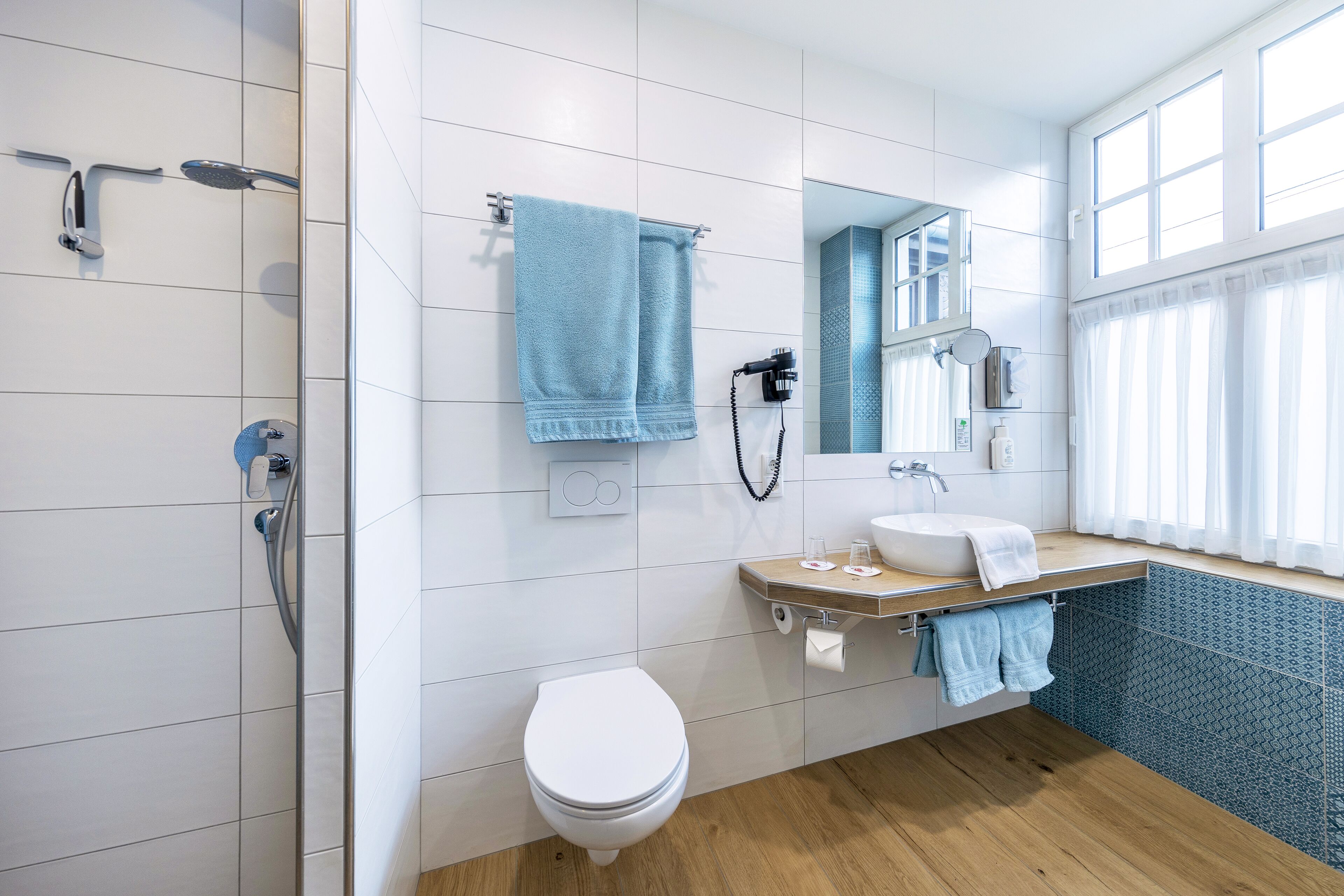 A modern bathroom with a shower, toilet, and sink.